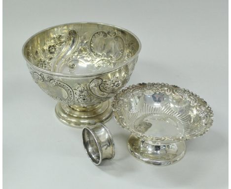 A late Victorian silver rose bowl of small proportions with embossed rose, floral and C scroll decoration raised on stepped c