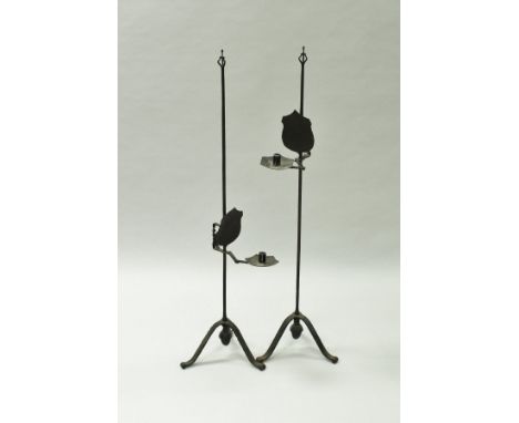 A pair of 19th Century wrought iron candle stands, the Arts and Crafts style finial on a plain tapered support bearing the ad