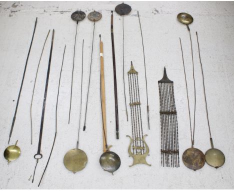 Eleven longcase clock pendulums and rods; also some spare pendulum rods, eight longcase clock seat boards and a Scottish pend