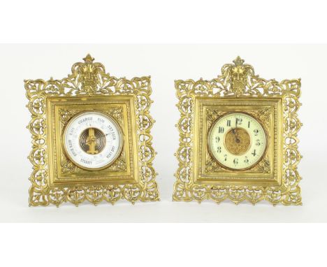 Brass easel cased clock timepiece and matching aneroid barometer, both within foliate pierced frames surmounted by the mask o