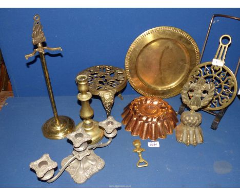 A quantity of brass including trivet, candlestick, charger, doorstop, copper jelly mould etc.