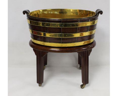 19th century mahogany brass bound planter of trim handled oval form, with removable brass liner, on oval stand with four reed