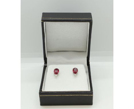 Pair of platinum and ruby and diamond studs. boxed