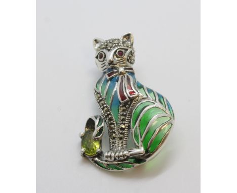 Silver brooch/pendant of a cat sitting with oval peridot, ruby eyes, marcasite and a plique-a-jour.