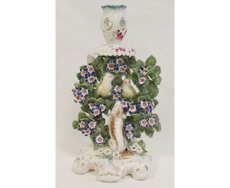 18th century Derby porcelain candlestick with a pair of birds perched in bocage with begging dog at foot, on domed scroll pli