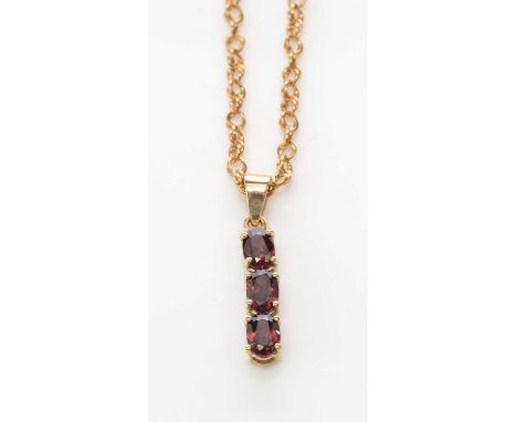 A garnet pendant, set with three oval facet-cut garnets, in 9ct. yellow gold mount, 3.2cms high, on 9ct. yellow gold twist li