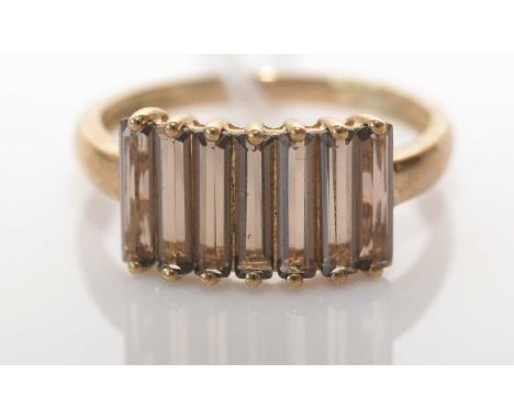 A smokey quartz ring, the seven rectangular step-cut smokey quartz stones claw set to a 9ct. yellow gold shank, ring size P, 