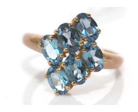 A London blue topaz ring, set with six oval facet-cut topaz, on 9ct. yellow gold shank, ring size P, 3.2grms gross.