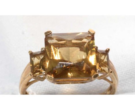 A citrine ring, the central square step-cut citrine flanked by two smaller rectangular step-cut citrines, on 9ct. yellow gold