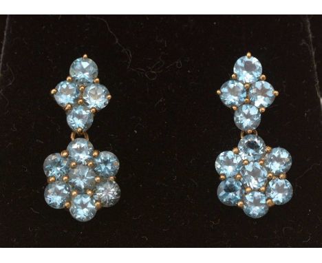 A pair of London blue topaz cluster drop earrings, each set with a cluster of seven facet-cut topaz below a mount set with fo