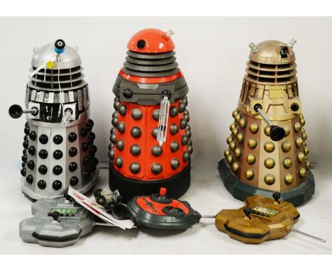 Three Doctor Who radio controlled Daleks, comprising one silver, one golden and one in red and grey, each with controller and