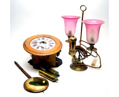 An early 20th Century "postman's" alarm wall clock and pendulum; and a vintage brass lamp with ruby shades. (2)