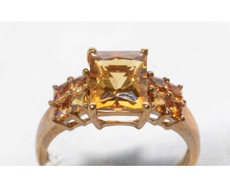 A citrine ring, the principal rectangular step-cut citrine flanked by four square step-cut citrines to each shoulder, on 9ct.