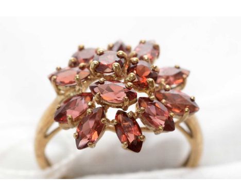 A garnet cluster ring, set with circular and marquise-cut garnet, on 9ct. yellow gold shank, ring size R, 3.6grms gross.