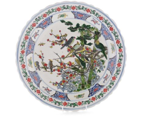 A Kangxi style charger, decorated in famille vert colours with birds, rockwork, bamboo and prunus, six character mark in unde