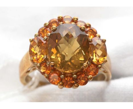 An orange Madeira citrine and smokey quartz cluster ring, the central fancy-cut smokey quartz surrounded by oval and circular