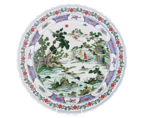A Kangxi style charger, decorated in famille verte colours with figures in a romantic landscape, six character mark in underg