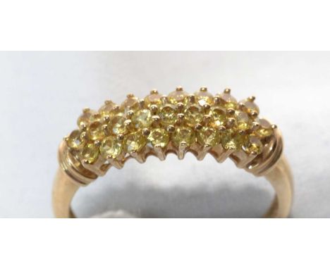 A yellow sapphire ring, set with twenty-five circular facet-cut yellow sapphires in three rows, on 9ct. yellow gold mount, ri