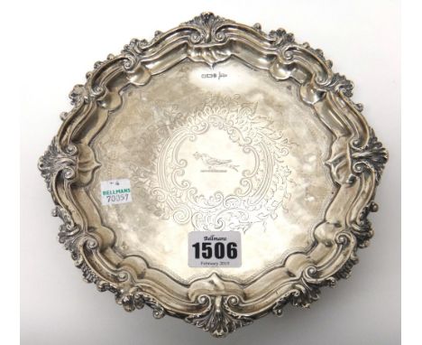 A silver salver, of shaped circular form, in the Chippendale style with a pie crust rim, crest engraved to the centre, within