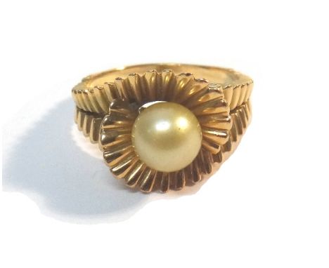 A gold ring, mounted with a single cultured pearl, the mount in a twistover fanned abstract design, ring size P, gross weight