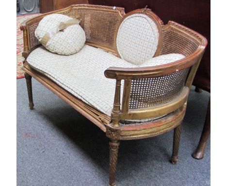A Louis XVI style gilt framed tub back sofa on spiral fluted supports, 120cm wide, (a.f.). 