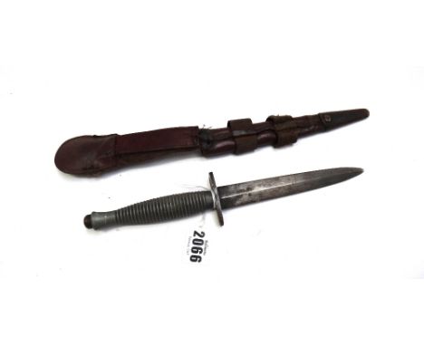 A WW2 Commando knife in a leather scabbard, the blade 14.8cm (a.f).