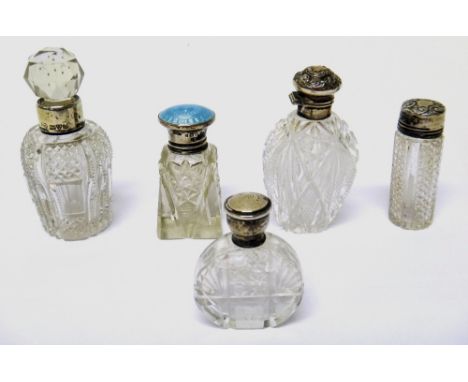 A silver and pale blue enamel topped, faceted glass, smelling salts bottle, London 1929 and four silver topped, faceted glass