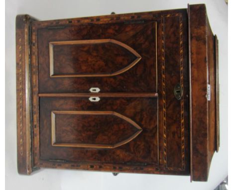 A 19th century figured walnut table top cabinet with lift top over a pair of arch panel doors, 35cm wide. 