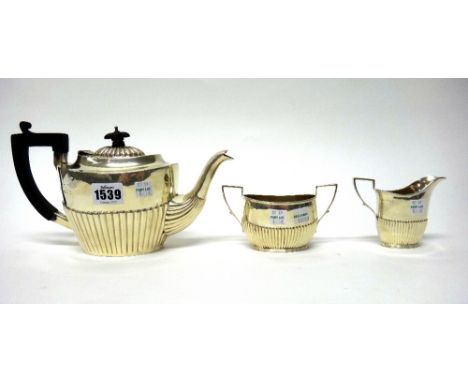 A silver composite three piece tea set, each piece of oval form, with partly fluted decoration, the teapot with black fitting