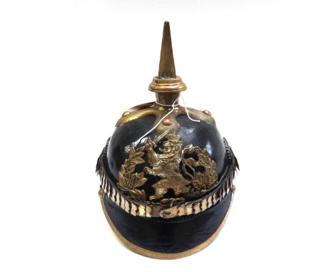 A Pickelhaube style helmet with brass spike and crest, painted cockades and a brass chinstrap with leather lining to the inte