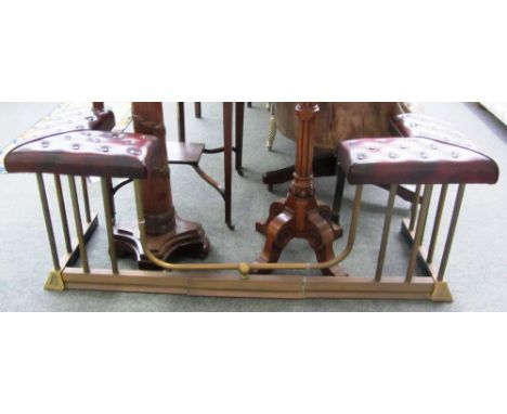 A Victorian style brass and adjustable rouge leather button mounted adjustable club fender, the corner seats raised on reeded