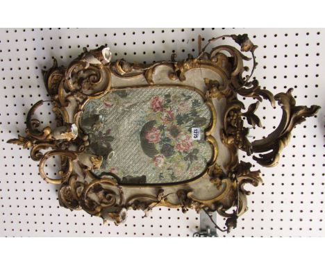 A pair of 19th century cream painted parcel gilt wall mirrors, each with shaped mirror plate, foliate scroll frame and four l