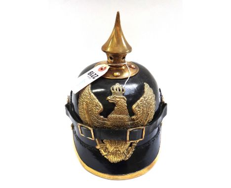 A Pickelhaube style helmet with brass spike and crest, painted cockades and a leather chinstrap with leather lining to the in