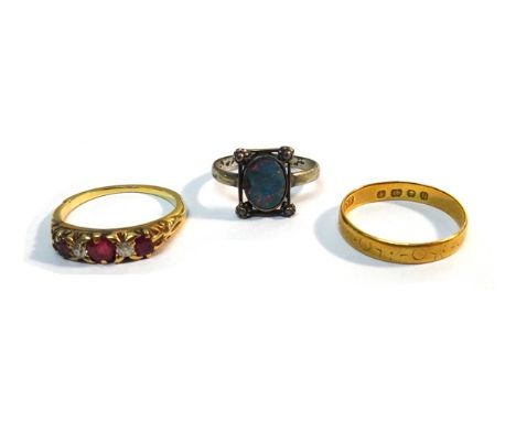 A gold, ruby and diamond set five stone ring, claw set with three cushion shaped rubies, alternating with two cushion shaped 