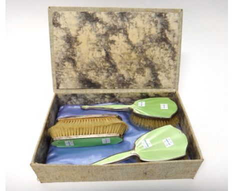 A lady's silver and pale green enamel mounted five piece dressing set, comprising; a hand mirror, a pair of hairbrushes and a