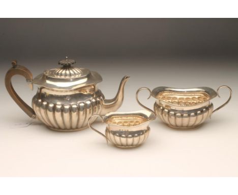 AN EDWARDIAN THREE PIECE SILVER TEA SERVICE, maker's mark JG, Birmingham 1902, of semi-ribbed oval form, comprising teapot, t