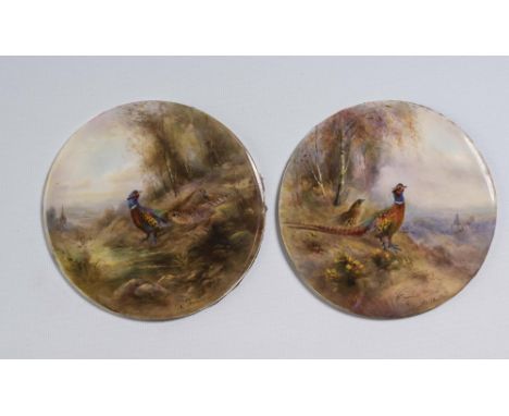 A PAIR OF ROYAL WORCESTER CHINA ROUNDELS, 1916, painted in polychrome enamels by James Stinton with pheasants in landscape wi