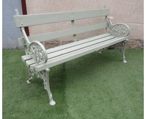 A CAST IRON GARDEN BENCH with slatted wood back and seat, the shaped sides moulded in a trailing vine pattern, 63 1/2" x 15" 
