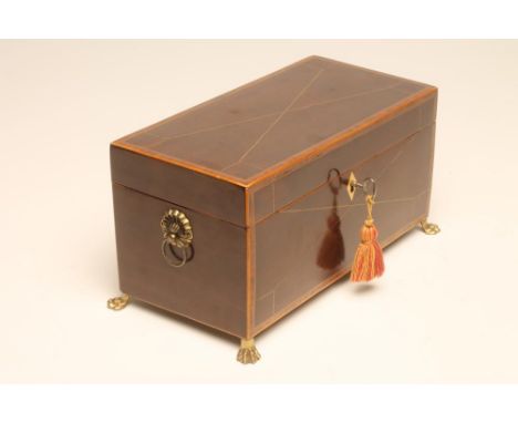 A MAHOGANY TEA CADDY, early 19th century, of plain oblong form raised upon four cast brass paw feet and with lion mask ring h