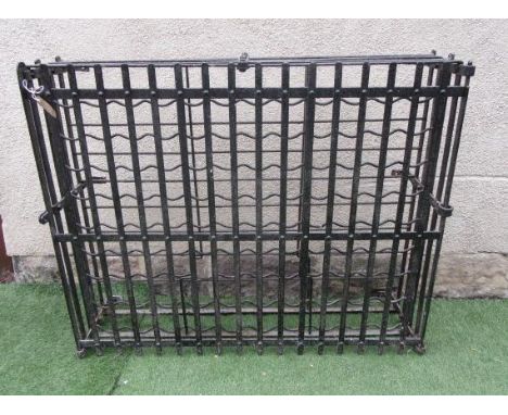 A CAST IRON WINE RACK, early 20th century, of shallow oblong form with slatted top and sides, and similar swing gate to the f