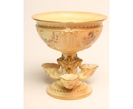 A ROYAL WORCESTER CHINA BLUSH IVORY CENTREPIECE, 1905, the strapwork moulded bowl raised upon a single knopped stem issuing f