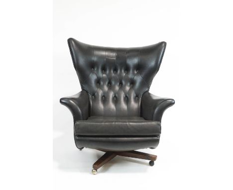 A G-plan swivel 'Blofeld, armchair, circa 1960, button back upholstered in black fabric, on rosewood tripod base and casters,