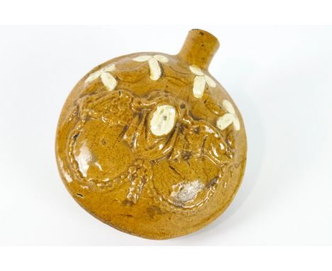 A Staffordshire pottery ochre glazed compressed circular flask, probably late 18th century, moulded with a winged mask for su