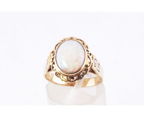 A yellow metal single stone ring set with an oval cabochon opal measuring approximately 11.0mm x 9.00mm. Size M. Stamped 9K 3