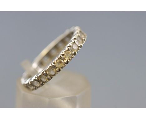 A white metal full eternity ring set with colourless synthetic spinel. Hallmarked 9ct gold, London, 1958. Size: K 2.9 grams