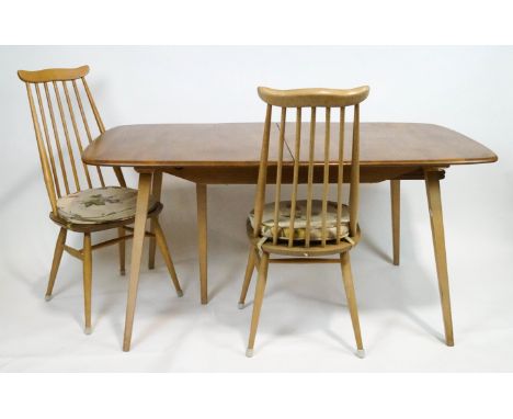 An Ercol beech and elm extending rectangular table with two leaves and table protector, together with six stick back dining c