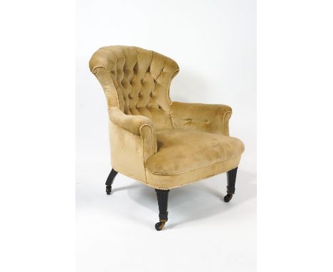 A Victorian armchair with shaped buttonback on square tapering fluted ebonised legs, on brass ceramic casters, 85cm high (ove