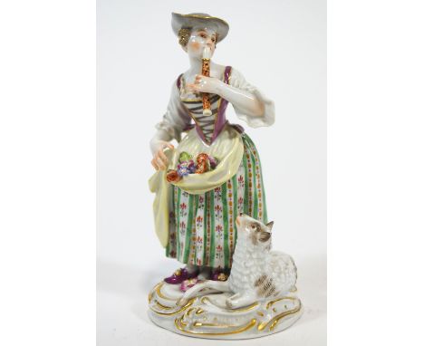 A porcelain Meissen style figure of a shepherdess playing a pipe, in polychrome clothing, holding a selection of flowers in h