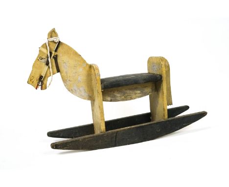 A vintage painted wood rocking horse of simple plank construction, with padded and studded seat and leather bridle, 105cm lon