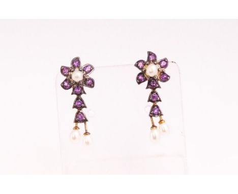 A yellow and white metal pair of drop stud earrings, each set with amethysts and seed pearls. Post and scroll fittings. No ha